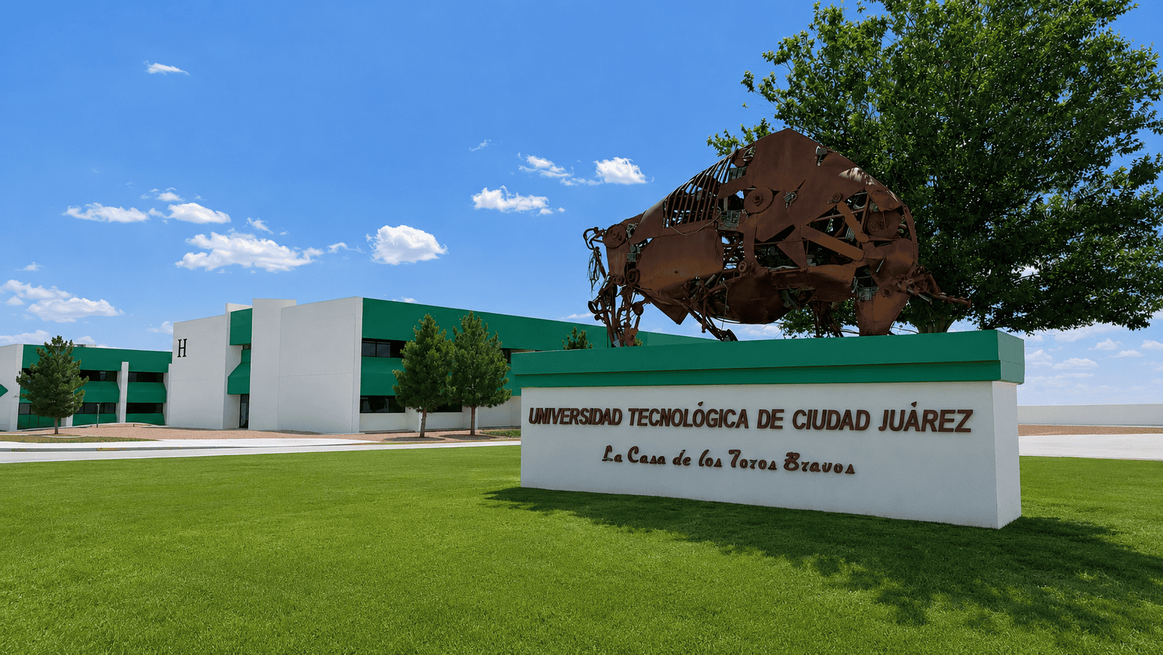Fachada de la Universidad Tecnológica de Ciudad Juárez con escultura de toro de metal.